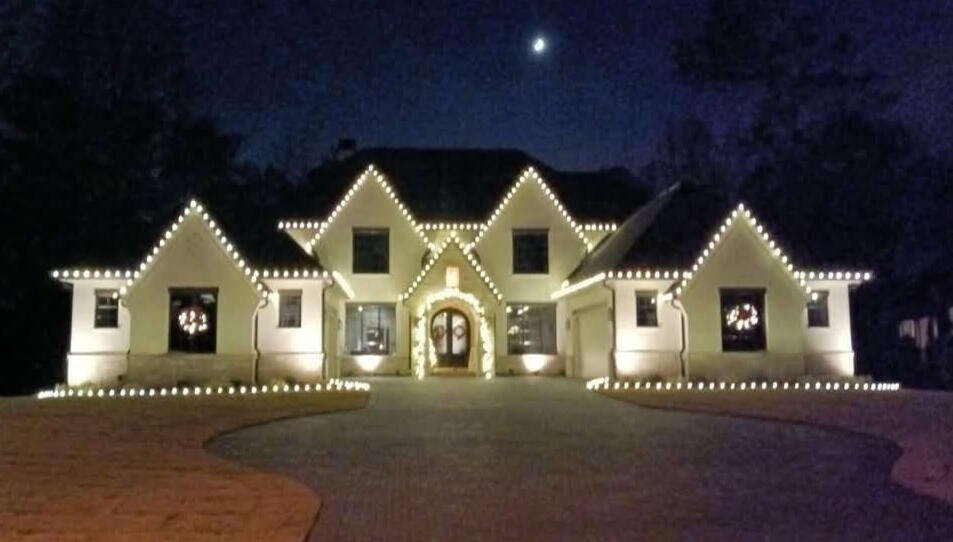 Modern home Modern white home with warm white Christmas lights on every peak and the driveway