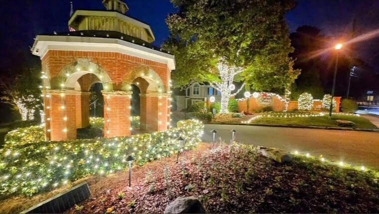 HOA gazebo Brick HOA gazebo outlined in holiday lights with lit hedges